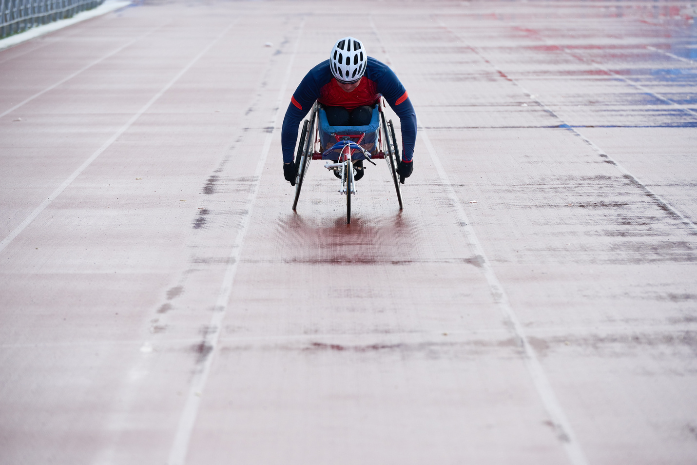 Paralympic champion in sport wheelchair approaching finish line